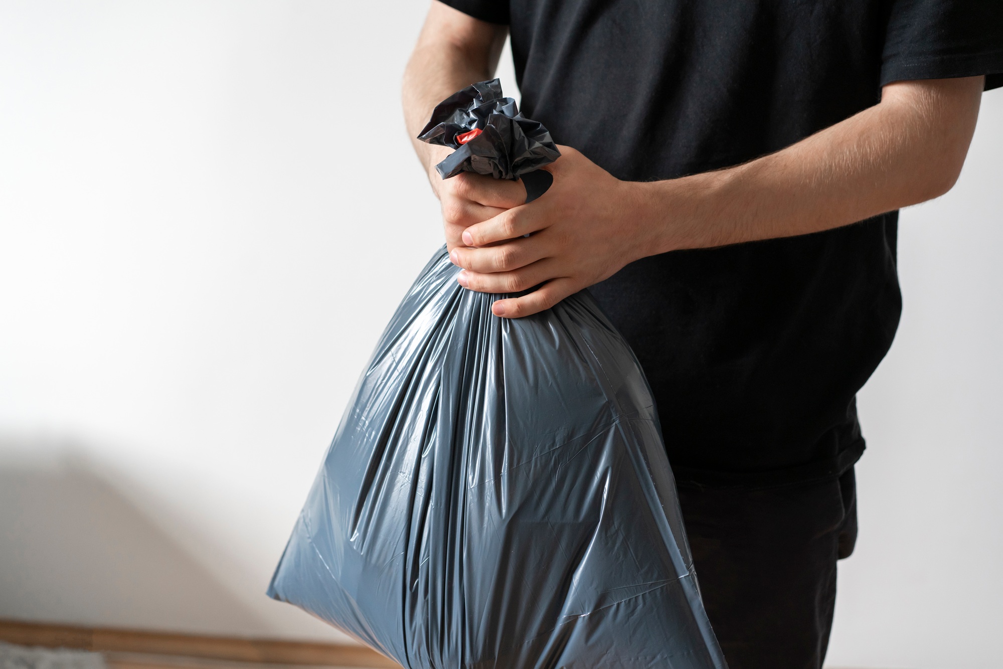 holding plastic garbage bag, take out the trash
