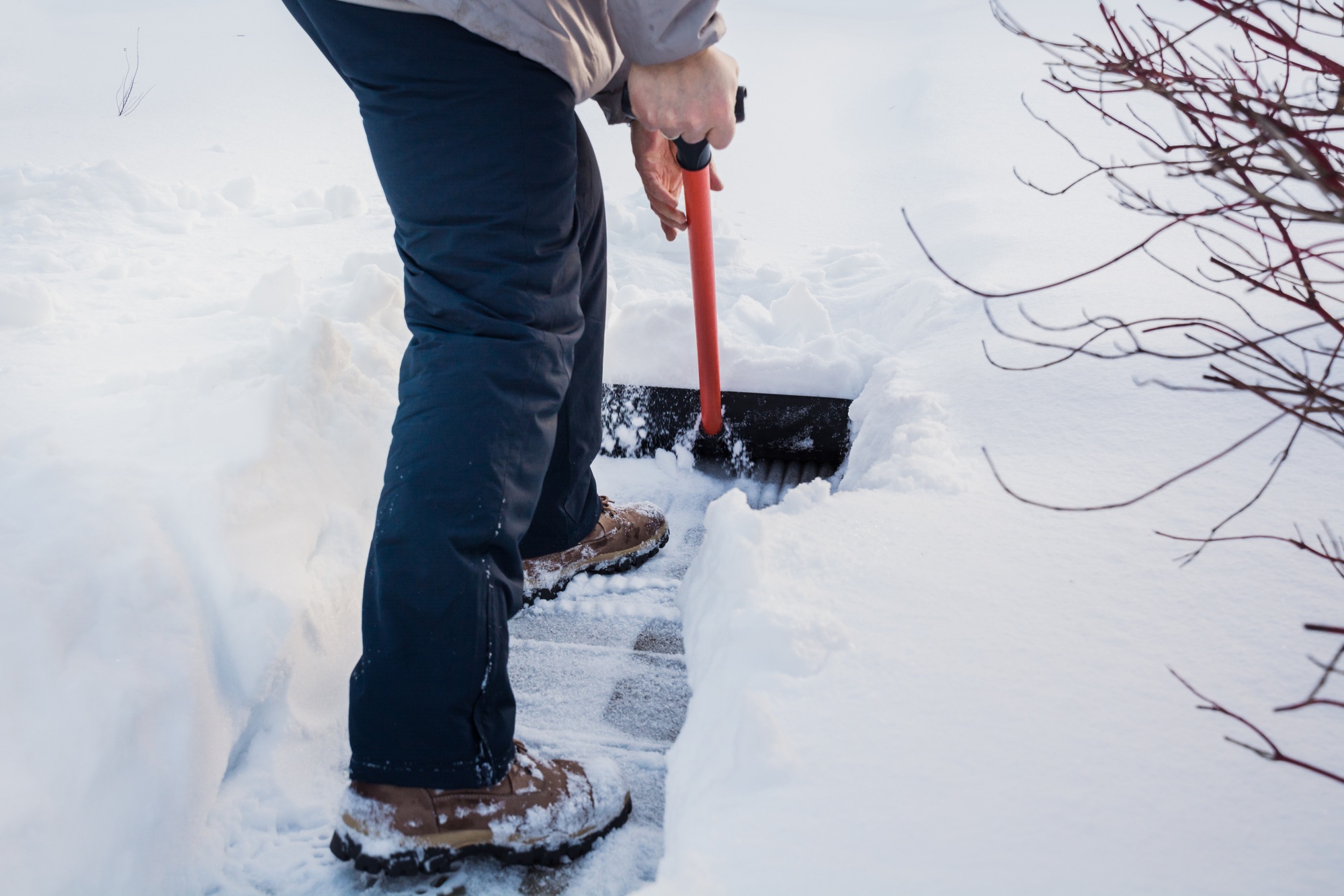 Snow removal. Man clearing snow by shovel after snowfall. Outdoors.